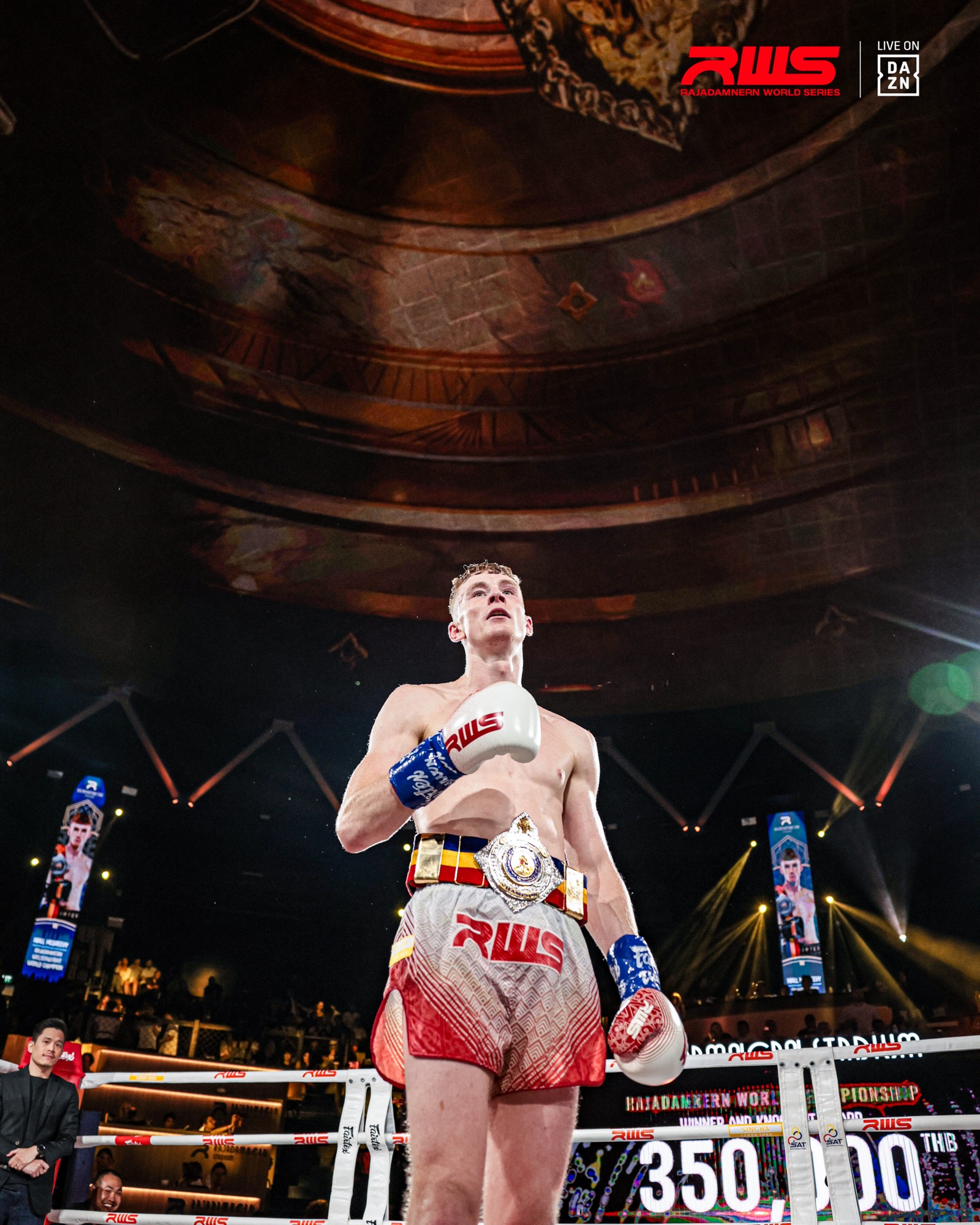 Fighter in the ring wearing a championship belt, gloves raised